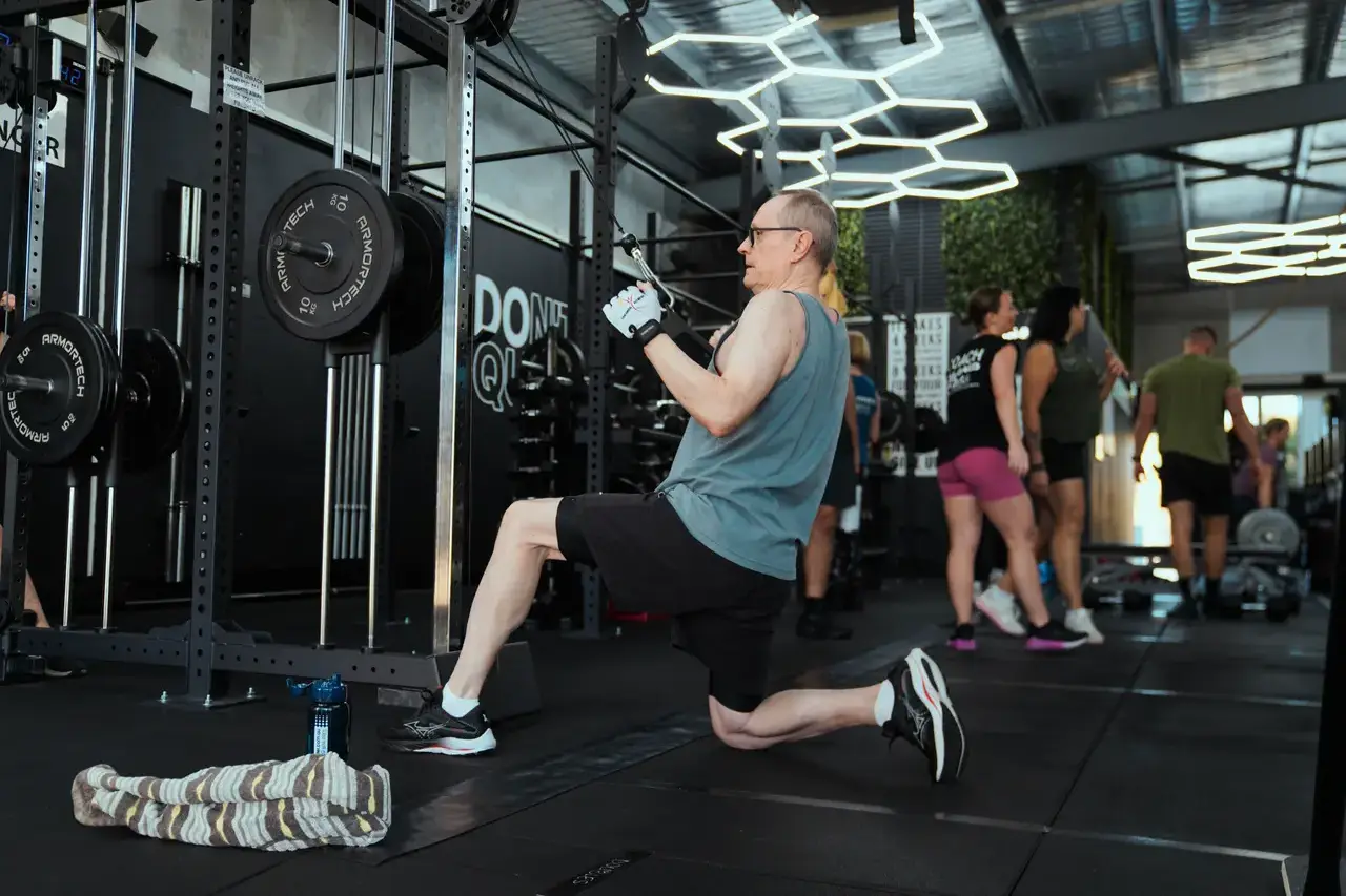 A member aged 60+ working through a coached cable row