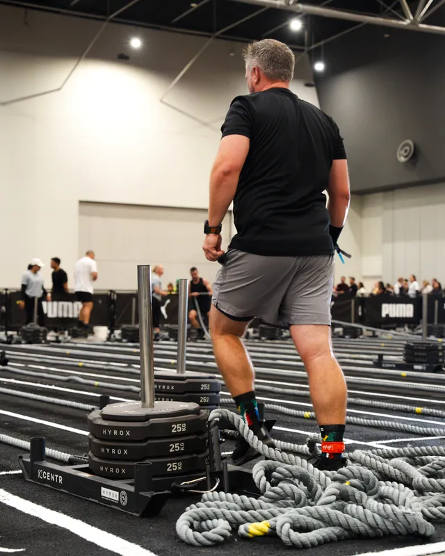 A competitor driving the sled at a HYROX Perth event