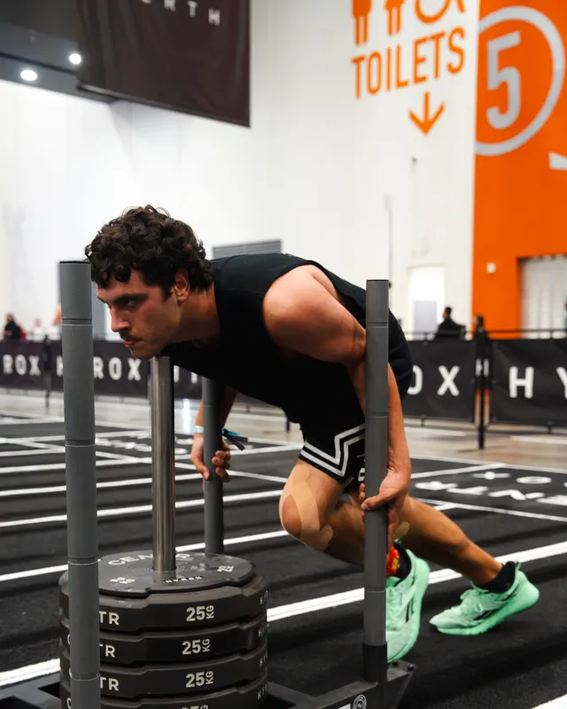 A competitor driving through the sled push at a HYROX Perth event